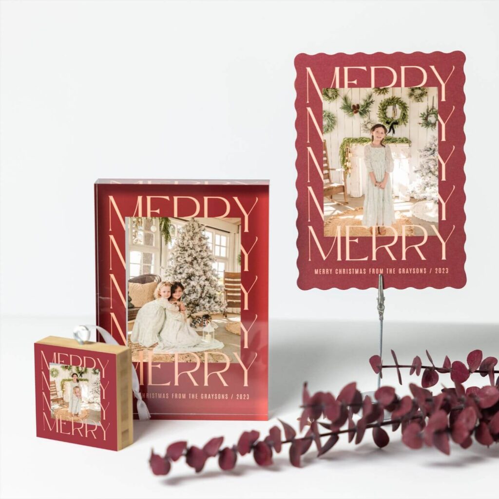 A photo featuring an ornament, desktop acrylic block, and holiday card. All have matching holiday designs with the word merry.